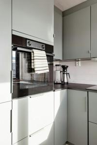 a kitchen with white cabinets and a stove at New Cabin With Panoramic Views At Hardangervidda in Eidfjord