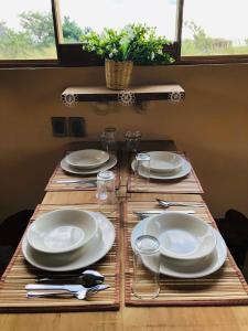 a table with white plates and utensils on it at Casa MANDALA in Santa María Colotepec