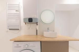 a bathroom with a washing machine and a mirror at La perle de Montargis - Charmant T2 in Montargis +3 photos