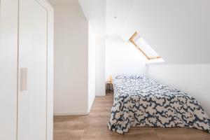 a bedroom with a bed with a blue and white blanket at La perle de Montargis - Charmant T2 in Montargis