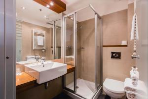 a bathroom with a sink and a shower and a toilet at Hotel Museum Budapest in Budapest