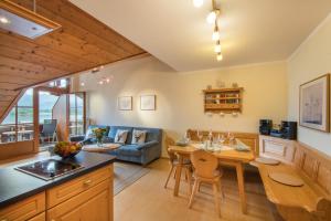 a kitchen and living room with a table and a couch at Residenz Sonnenhang I in Füssen