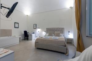 a white bedroom with a bed and a bathroom at Il Tesoro Smart Suite & SPA in Naples