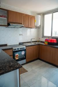 a kitchen with wooden cabinets and a stove top oven at Immeuble Avenue 30 Juin - Lubumbashi in Lubumbashi