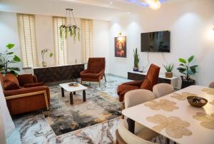 a living room with chairs and tables and a tv at Immeuble Avenue 30 Juin - Lubumbashi in Lubumbashi