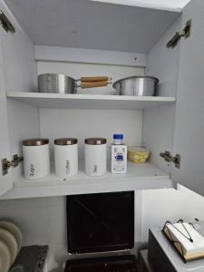 a kitchen with white shelves with pots and pans at Upscale homes in Ongata Rongai 