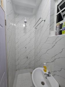 a white bathroom with a sink and a shower at Upscale homes in Ongata Rongai  +6 photos