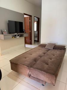 a large bed in a room with a flat screen tv at Casinha da Canastra in Delfinópolis