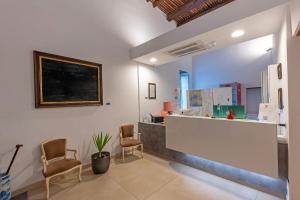 a waiting room with two chairs and a counter at Il Tesoro Smart Suite & SPA in Naples +76 photos