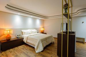 a bedroom with a large bed and two lamps at Alven Hotel by Slaviero Hotéis in Joinville