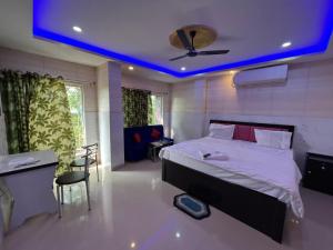 a bedroom with a bed with a blue ceiling at Top Comfort in Kolkata