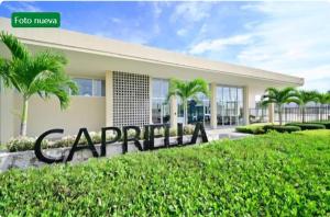 a sign in front of a building with palm trees at Capriella,Cartagena in Cartagena de Indias
