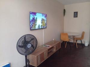 a living room with a fan and a table at Comfy spacious apartment in Pretoria