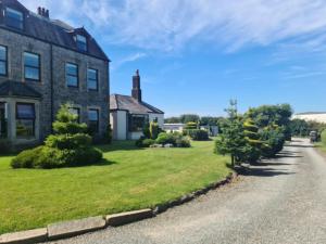a house with a green yard next to a road at Duddon Villa in Millom