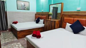 a room with two beds and a mirror at Hotel Raj in Siliguri