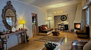 a living room with a couch and a clock on the wall at Guesthouse Mavrodimos in Eptalofos
