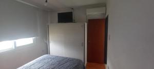 a bedroom with a bed and a white refrigerator at El Chalten hospedaje diario in General Pico