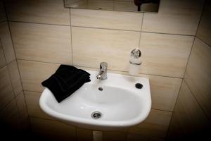 a white sink in a bathroom with a black towel at Penzion Nattali in Poprad +80 photos