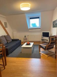 a living room with a couch and a table at Ferienwohnung Kirchturmblick Euren in Trier