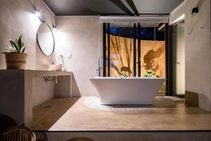 a bathroom with a large tub and a window at Tava Glamping Cerro in San Bernardino +39 photos