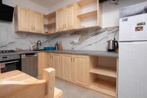 a kitchen with wooden cabinets and a white refrigerator at Pod Hawraniem pokoje z widokiem na Tatry Ski & Bike Friendly Jurgów in Jurgów