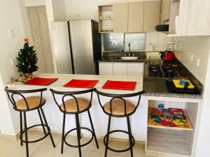 a kitchen with a christmas tree and two bar stools at Cerca al centro, piscinas & jacuzzis y muy dotado in Villeta
