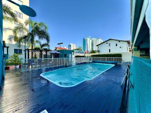 a swimming pool on the deck of a building at Apto em Barra Velha 340m da PRAIA com SACADA com CHURRASQUEIRA, AR CONDICIONADO WI-FI, PISCINA, PORTARIA 24h, ACADEMIA MINI MERCADO e vaga de GARAGEM in Barra Velha +28 photos