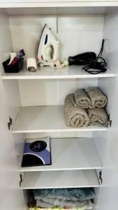 a closet with white shelves with towels and a appliance at Monoambiente Eldorado 6 in Eldorado