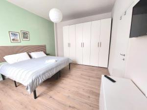 a bedroom with a bed and a flat screen tv at Grazioso Bilocale in Busto Arsizio +1 photo