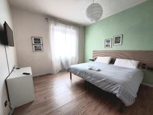 a bedroom with a large bed with a green wall at Grazioso Bilocale in Busto Arsizio