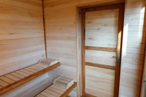 a small wooden sauna with a wooden door at Chez Oreste - Escapade à 2 avec sauna et jardin clos in Aywaille