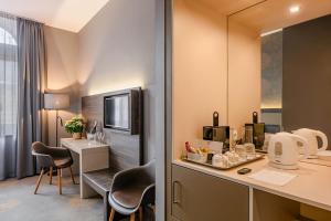 a hotel room with a kitchen with a counter and chairs at Hotel Museum Budapest in Budapest