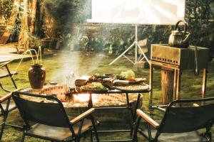 a barbecue with chairs and a table with food on it at Nostalgia Villa Dalat in Ấp Ða Lợi