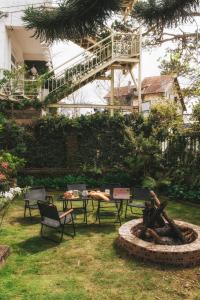 a garden with tables and chairs and a fire pit at Nostalgia Villa Dalat in Ấp Ða Lợi