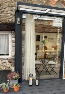 a sliding glass door to a patio with a table at Charmant Studio in Le Breuil-en-Bessin