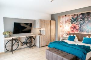 a bedroom with a bed and a tv and a bicycle at Landhotel Schwabenhof in Heiligenbrunn