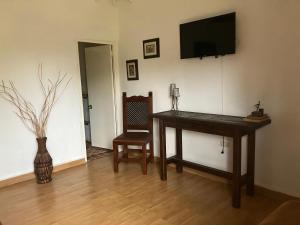 a room with a desk and a television on a wall at La Kolorina hotel campestre in Jericó