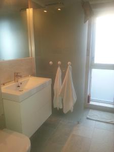 a bathroom with a sink and a toilet and a mirror at Moderne feriehus in Laupstad