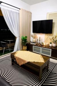 a living room with a flat screen tv and a coffee table at Homestay Tysha in Kampong Pulau Sebang