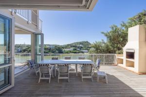 a patio with a table and chairs on a deck at 53 Island Road in Seafield