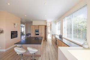 a kitchen with a black counter and white stools at 53 Island Road in Seafield