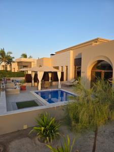 a house with a swimming pool in front of it at Beach Villa mit Privatpool, Dachterrasse in Ma‘mūrah