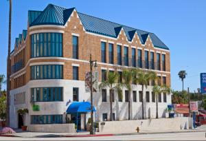 um grande edifício com palmeiras em frente em Century Park Hotel LA em Los Angeles