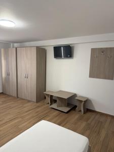 a room with a desk and a table and cabinets at Casa Drăghici in Nucet