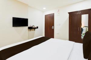 a bedroom with a bed and a flat screen tv at Townhouse Gachibowli Near Gopichand Academy in Hyderabad +47 photos