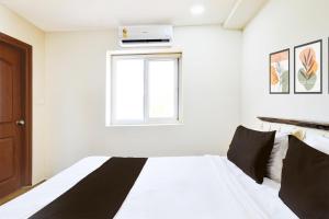 a bedroom with a bed and a window at Townhouse Gachibowli Near Gopichand Academy in Hyderabad