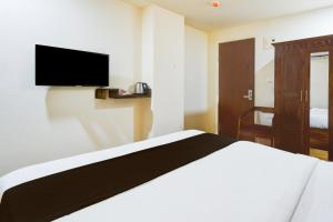 a bedroom with a bed and a tv on the wall at Townhouse Gachibowli Near Gopichand Academy in Hyderabad