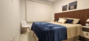 a bedroom with a large bed with a blue blanket at Dream Apartment-Rooftop, Pool, Mountain & Sea View in Capão da Canoa +15 photos