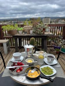 a table with plates of food on a balcony at Casa Mirador Pichilemu in Pichilemu