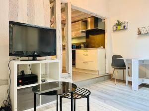a living room with a tv and a table at Charmante maison triplexe avec jardinet in Orléans
